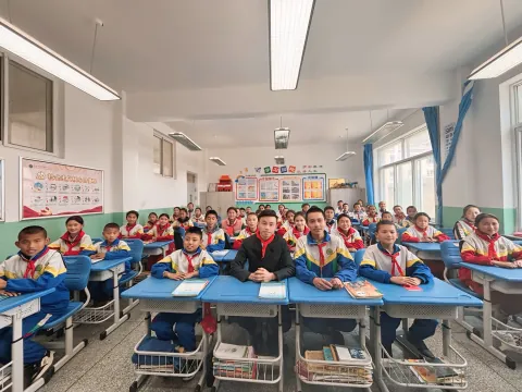 走进教室与受助学生合影